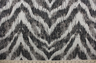 On the Prowl is a stylish upholstery fabric that features a unique abstract chevron pattern in black and linen colors. With a testing score of 25,000 double rubs, the fabric is abrasion and wear-resistant, providing long-lasting durability and quality over time.