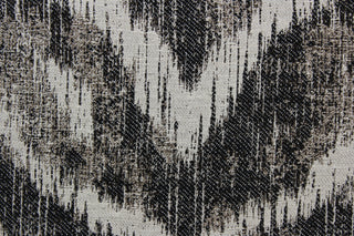 On the Prowl is a stylish upholstery fabric that features a unique abstract chevron pattern in black and linen colors. With a testing score of 25,000 double rubs, the fabric is abrasion and wear-resistant, providing long-lasting durability and quality over time.