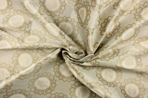 This fabric feature a medallion design in beige and tan .