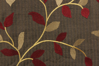  This fabric features a embroidery vine and leaf design in dark red, gold and tan against a dark brown . 