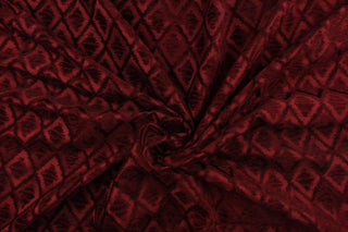  This fabric features a diamond design in rich burgundy  . 
