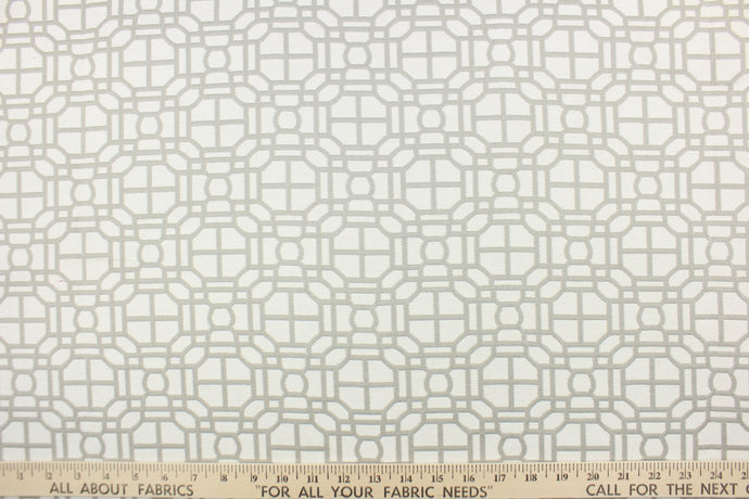  This fabric features a geometric design in gray and white . 