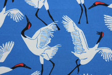 Load image into Gallery viewer, Black Cranes is a printed polyester outdoor fabric featuring a beautiful, bold cobalt blue background with white and black cranes.  The fabric is fade resistant, water repellant and provides up to 33,000 double rubs of wear-resistance, making it ideal for outdoor furniture and accessories.  Uses include cushions, tablecloths, upholstery projects, decorative pillows and craft projects. 
