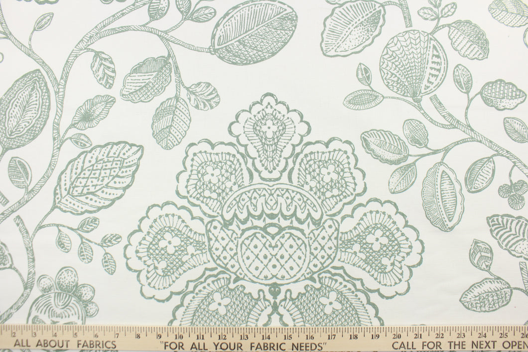 This fabric features a toile floral design in green against a white background. 