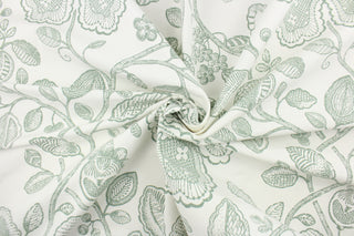This fabric features a toile floral design in green against a white background. 