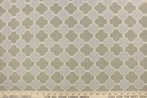 This fabric features a lattice quatrefoil design in taupe, gray and dull white. 