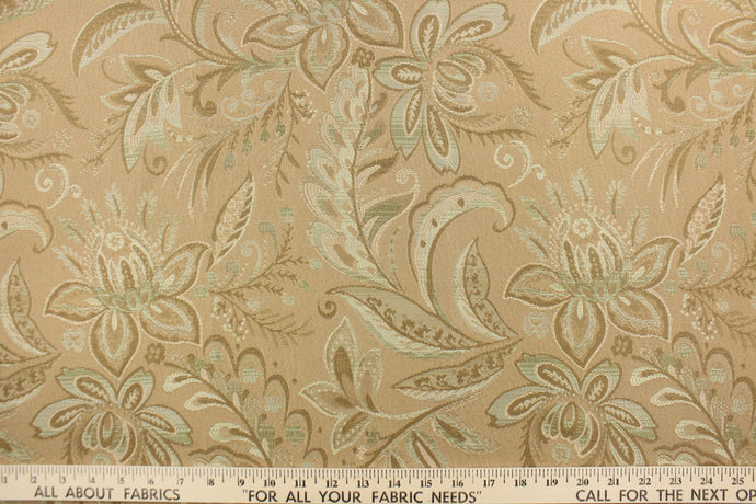  This tapestry features a floral design in seafoam green, tan and beige set against a rich khaki color . 