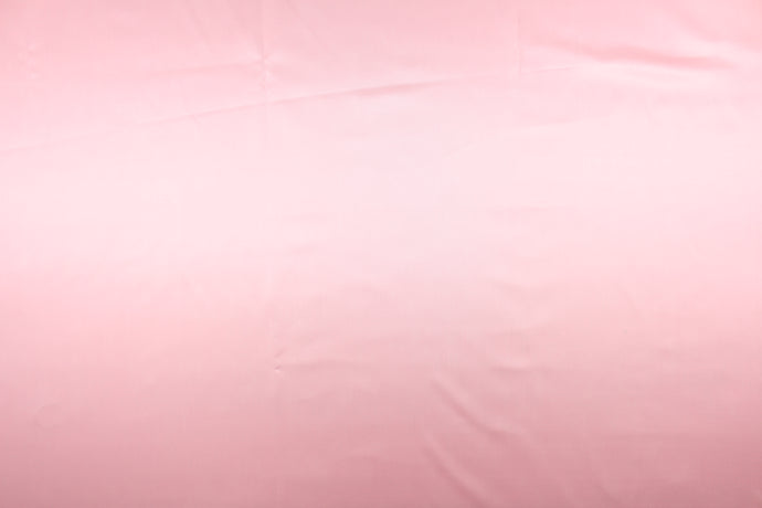 A beautiful satin fabric in a light pink color.