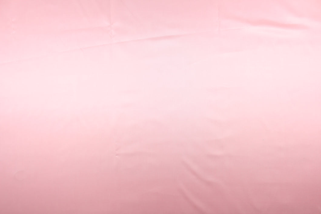 A beautiful satin fabric in a light pink color.