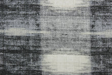 Load image into Gallery viewer,  Sashika Plaid features a beautiful multi-use ethnic plaid pattern, consisting of shades of grey and off white.  Offering up to 24,000 double rubs, this upholstery fabric ensures long-lasting durability and quality.  Uses include window treatments, pillow shams, duvet covers, toss pillows, slip covers, and light duty upholstery to create a complete interior design look.
