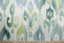 Load image into Gallery viewer, Lagrande is a multi use fabric featuring an ikat print design in blue, green and ivory.  The fabric is treated with a soil and stain repellant finish for lasting performance, rated for up to 15,000 double rubs.  The versatile fabric is perfect for window accents (draperies, valances, curtains and swags) cornice boards, accent pillows, bedding, headboards, cushions, ottomans, slipcovers and upholstery.  
