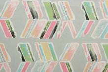 Load image into Gallery viewer, Spring In To Action features abstract arrows in colorful shades of pink, blue, green, white and yellow against a gray background. Its 51,000 double rubs ensures its durability and resilience.  Perfect for window accents (draperies, valances, curtains and swags) cornice boards, accent pillows, bedding, headboards, cushions, ottomans, slipcovers and light duty upholstery.  
