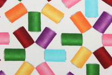 Load image into Gallery viewer,  This fabric features dancing spools of thread in rich and vibrant hues of red, yellow, orange, pink, green, purple and blue on a white background.  The versatile lightweight fabric is soft and easy to sew.  It would be great for quilting, crafting and sewing projects.  
