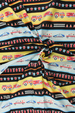Load image into Gallery viewer, Add a pop of color with this fabric that features brightly colored first responder vehicles that glow in the dark.  Each classic design has fine detail and the natural colors are touched with metallic gold.  This versatile lightweight fabric is soft and easy to sew.  It would be great for quilting, crafting and sewing projects.  Colors included are red, orange, blue, yellow, white and black.
