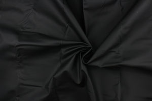 This vinyl fabric features a crackle design in solid dull black .