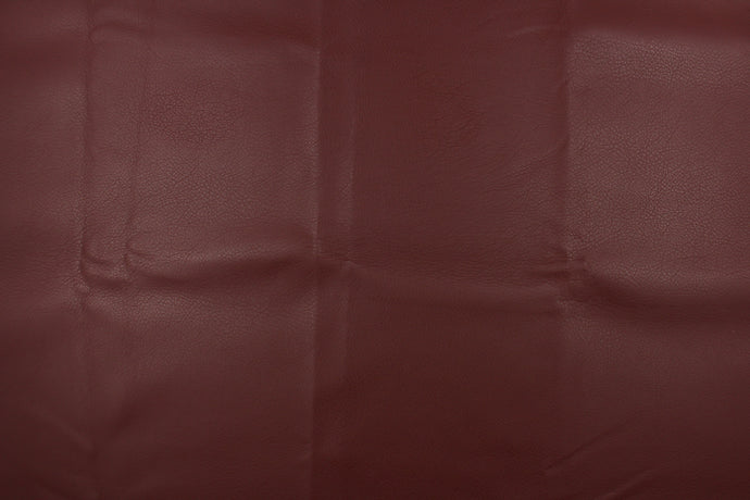 This vinyl fabric features a crackle design in rich reddish brown.