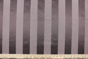 This fabric features a stripe design in a rich purple gray  with  a slight shine. 