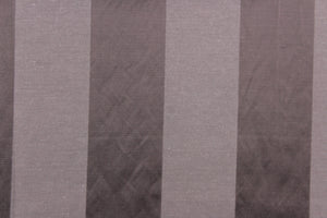  This fabric features a stripe design in a rich purple gray  with  a slight shine. 