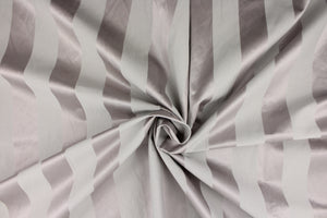  This fabric features a stripe design in gray with purple undertones  with  a slight shine.