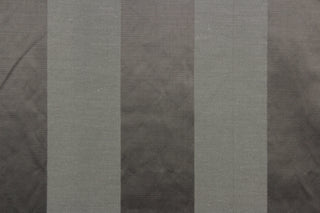 This fabric features a stripe design in dark gray with  a slight shine. 