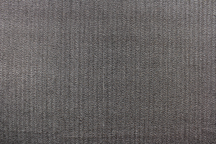  This wool features a herringbone design in brown and white with hints of tan .