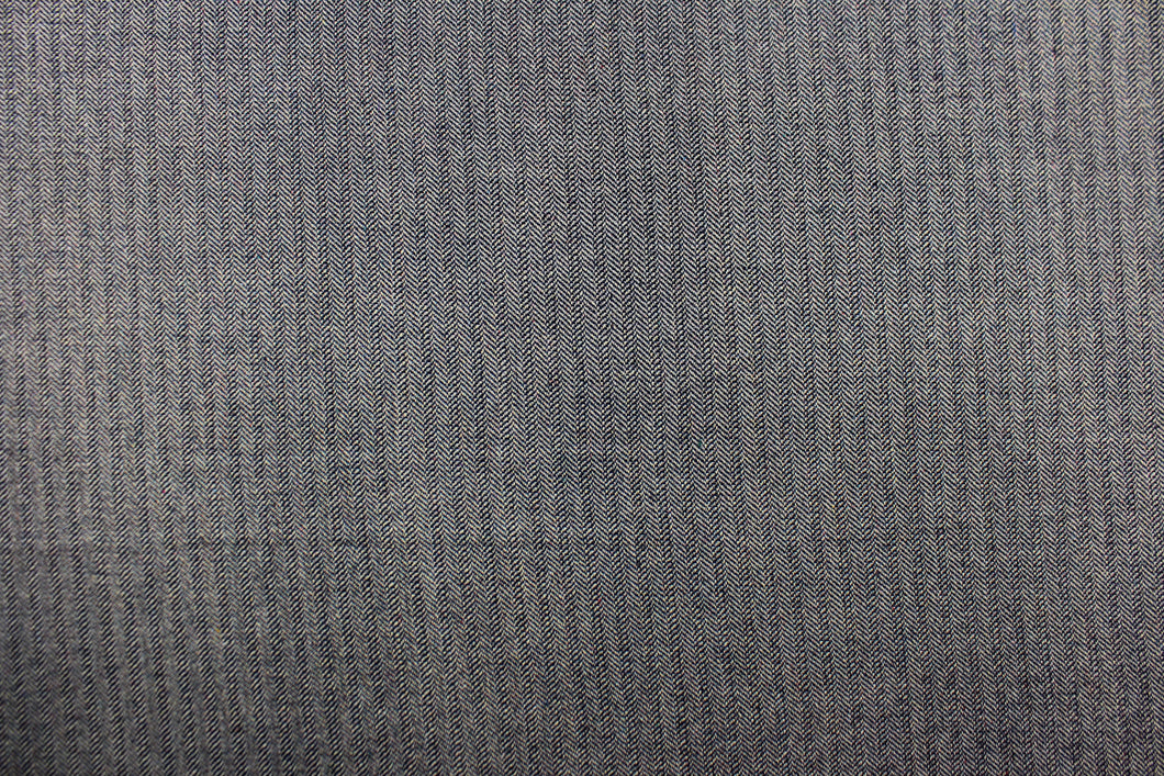 This wool features a herringbone design in blue and light beige or gray with hints of varying colors. 