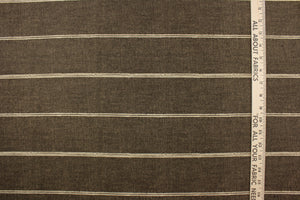 This fabric features a horizontal stripe design in light beige against   brown. 