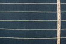 Load image into Gallery viewer, This fabric features a stripe design in a light beige against a rich blue. 
