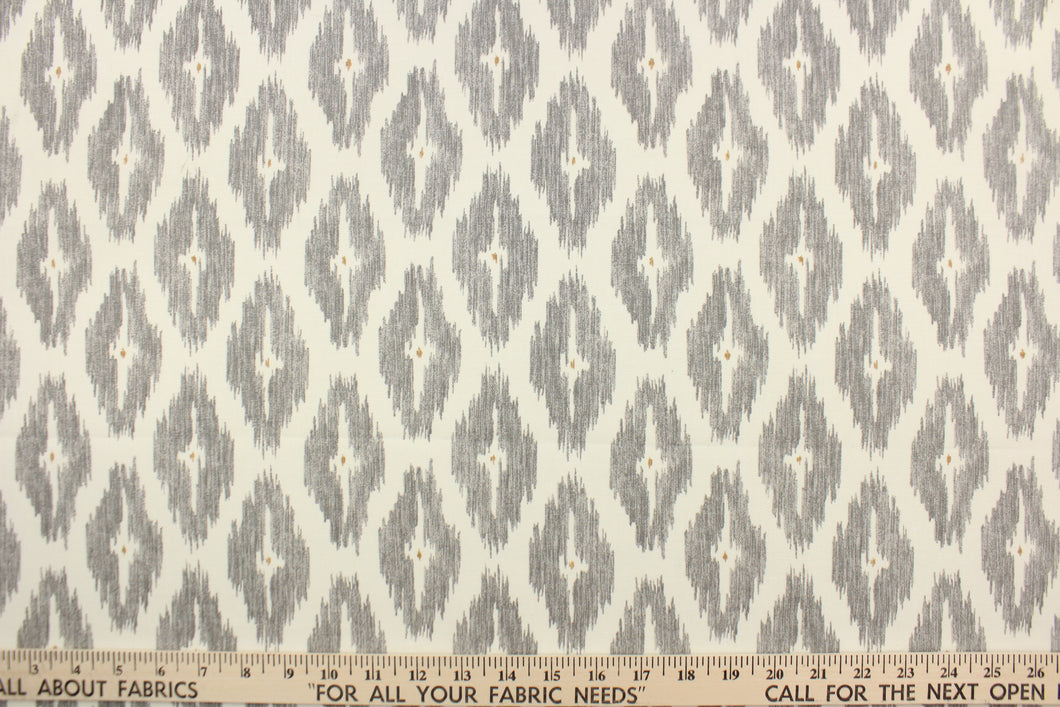 This geometric medium scale ikat design in gray and tan against white . 