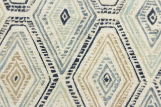 This fabric features a geometric design of diamonds in blue, white, tan and a seafoam . 