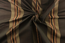 Load image into Gallery viewer, This rich woven yarn dyed fabric features bold multi width striped pattern in dark red or wine and gold on a dark brown background.
