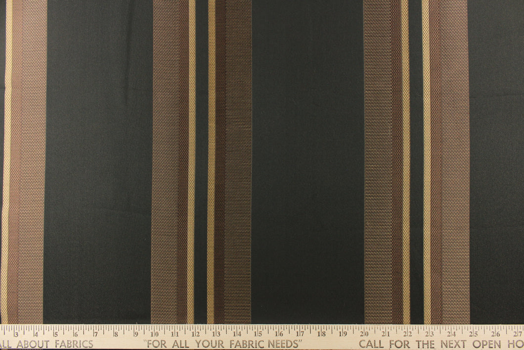 This rich woven yarn dyed fabric features bold multi width striped pattern in brown and gold on a black background