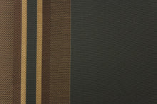 Load image into Gallery viewer,  This rich woven yarn dyed fabric features bold multi width striped pattern in brown and gold on a black background
