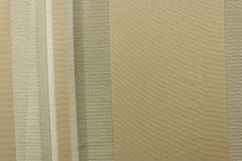 Load image into Gallery viewer,  This rich woven yarn dyed fabric features bold multi width striped pattern in shades of champagne on a khaki or beige background. 
