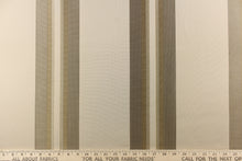 Load image into Gallery viewer,  This rich woven yarn dyed fabric features bold multi width striped pattern in dark gold and khaki on a light khaki or cream background. 
