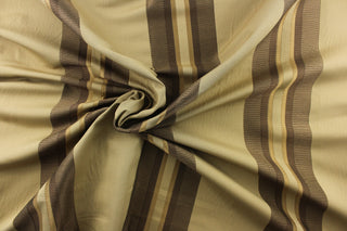This rich woven yarn dyed fabric features bold multi width striped pattern in shades of brown and gold on a dark beige background.