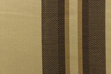 Load image into Gallery viewer, This rich woven yarn dyed fabric features bold multi width striped pattern in shades of brown and gold on a dark beige background.

