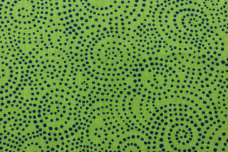 This whimsical print offers bold color and simplicity, with a simple design of swirls of tiny bold blue dots on a cabana green  background.