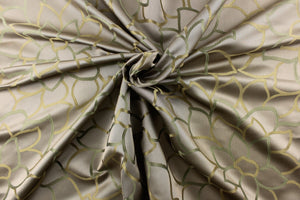 This elegant jacquard fabric features a woven floral design in a green and beige against a taupe brown.