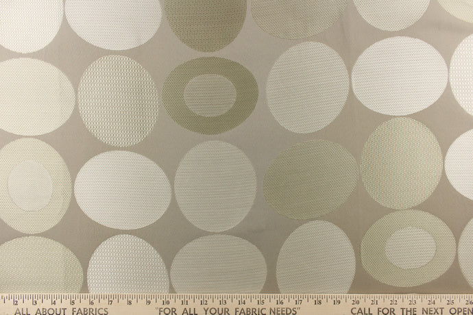  Stylish, modern and contemporary best describe this geometric pattern of circles and ovals in gray tones or champagne on a khaki background.