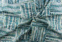 Load image into Gallery viewer, : This fabric has a geometric look with squares full of  rows of what looks like paint blots, in different tones of turquoise with hints of water blue and khaki set against a dull white. 
