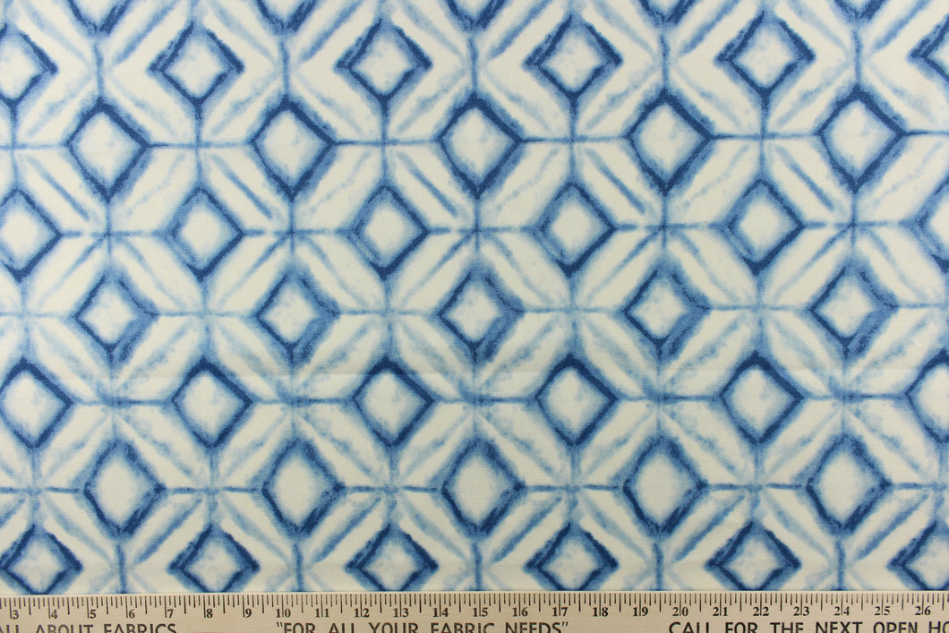  This fabric features a geometric design of diamonds in shades of blue with white.