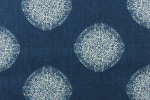 This fabric features a geometric design of circles in white on a blue background. 