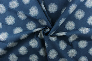 This fabric features a geometric design of circles in white on a blue background. 