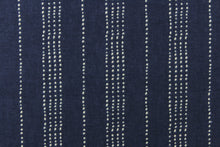 Load image into Gallery viewer, This fabric features a multiply white dot stripes against a blue background.
