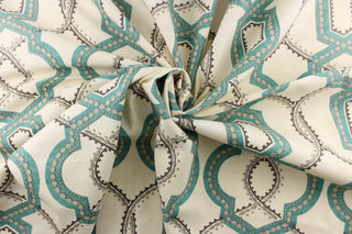 This contemporary design feature a geometric, quatrefoil pattern with gray, turquoise blue, and khaki colors on a natural background. 