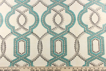 Load image into Gallery viewer, This contemporary design feature a geometric, quatrefoil pattern with gray, turquoise blue, and khaki colors on a natural background. 
