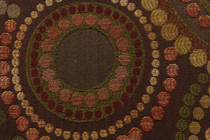  This contemporary geometric design features overlapping circles and dots in gold tones, green, and deep reds colors against a brown background.