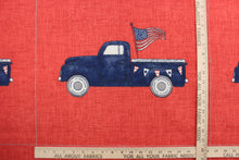 Load image into Gallery viewer, This indoor/outdoor fabric panel features a old blue pickup up truck with an American flag in its typical colors of red, white and blue on a solid red background.  Uses include patios, pillows and totes.  Approximate 6 prints per yard. 

