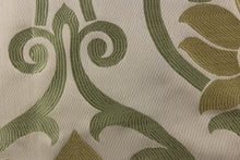 Load image into Gallery viewer, This elegant jacquard fabric features a woven ornamental damask design with hints of green and gold on a taupe background
